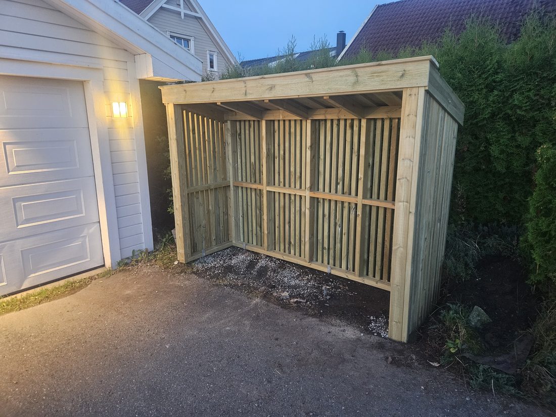 Søppelskjul i lyst impregnert treverk, ferdig montert ved en garasje